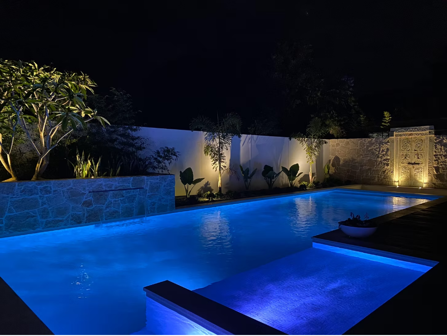 Piscina iluminada em ambiente residencial sofisticado